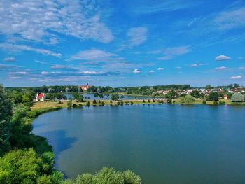 Scenic view of river by buildings against sky