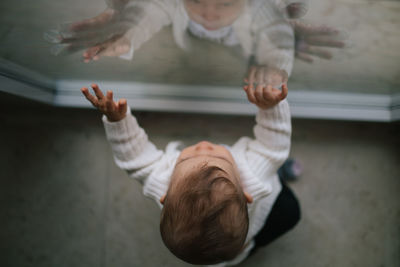 Directly above shot of baby boy standing by window at home