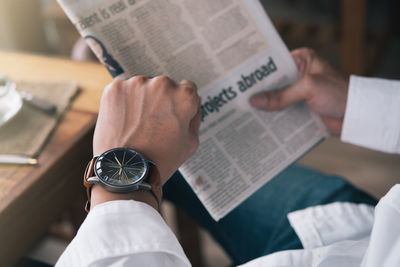 Midsection of man reading book on paper