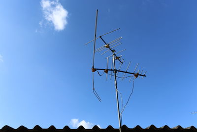 Low angle view of communications tower against blue sky