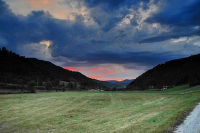 Scenic view of land and mountains against sky
