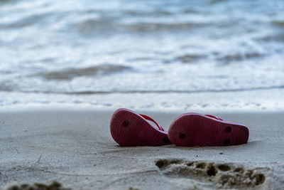 Close-up of red umbrella on beach