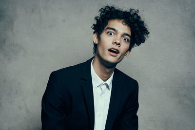 Portrait of young man standing against wall