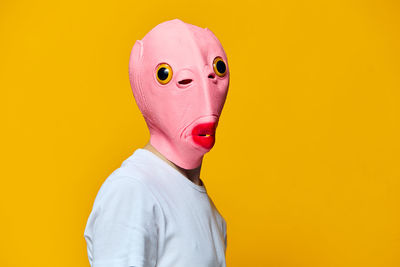 Man wearing mask against yellow background