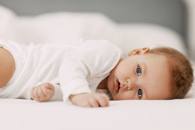 Cute baby lying down on bed