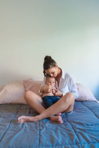 Boy sitting on bed at home