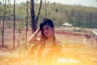 Portrait of woman standing against trees