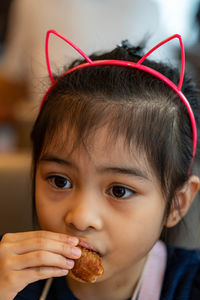Close-up portrait of cute girl eating food