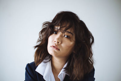 Young woman standing against white background