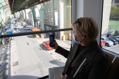 Woman looking out the window of wuppertaler schwebebahn, wuppertal suspension