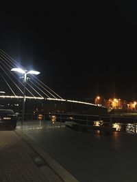 Illuminated bridge over river at night