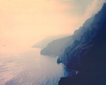 Scenic view of sea and mountains against sky