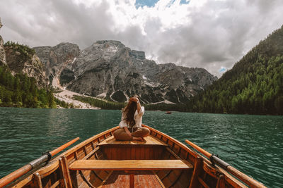 Rear view of woman looking at lake against mountain