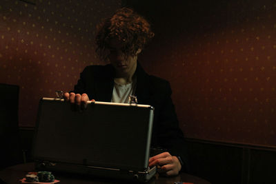 Full length portrait of young man sitting at home