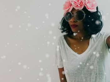 Portrait of woman wearing sunglasses and tiara during snowfall