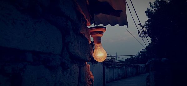 Low angle view of illuminated lanterns hanging by building