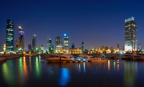 River and illuminated buildings in city at night