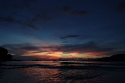 Scenic view of sea against dramatic sky during sunset