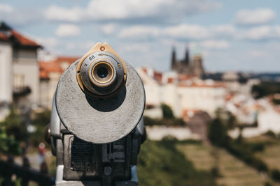 Close-up of coin-operated binoculars against buildings in city