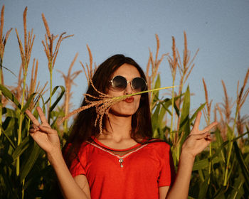 Portrait of young woman on sunglasses against sky