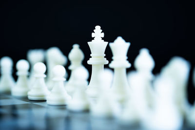 Premium Photo  Closeup of chess pieces on the chessboard under the lights  with a blurry background