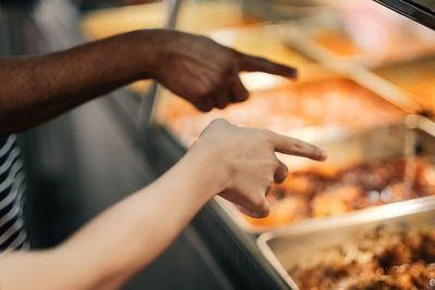 Two person pointing at the dishes in a restaurant