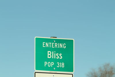 Low angle view of road sign against clear sky