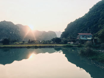 Scenic view of lake by buildings against sky