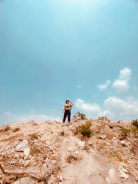 Woman standing on mountain against sky