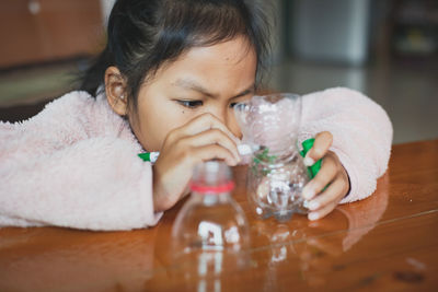 Cute girl playing with plastic bottle