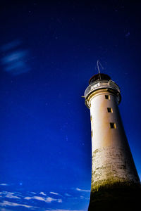 Low angle view of lighthouse against sky at night