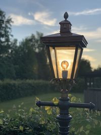 Close-up of illuminated street light against sky