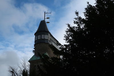 Low angle view of cross by building against sky