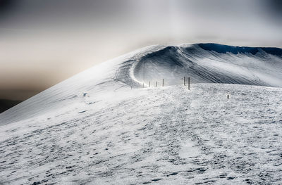 Snow covered land against sky