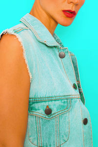 Midsection of woman standing against blue background