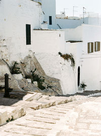 Footpath by wall and building in city