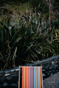 High angle view of cropped deck chair on footpath