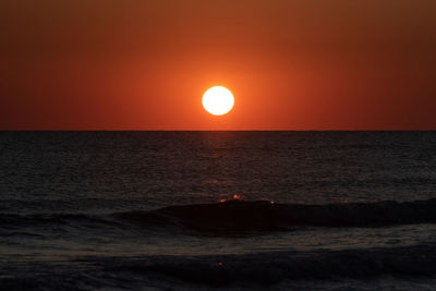 Scenic view of sea against orange sky