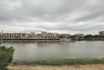 River by buildings against sky