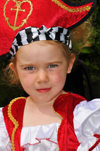 Portrait of girl in costume sitting outdoors