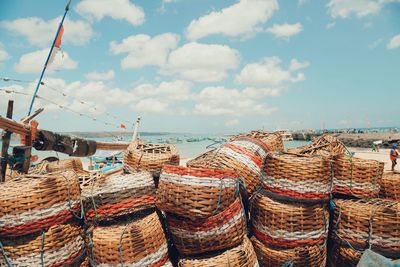 Stack of wicker baskets at beach against sky