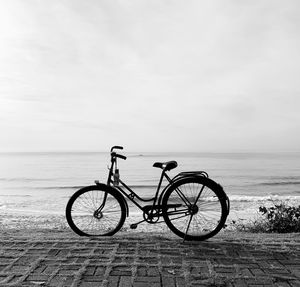 Bicycles on beach against sky