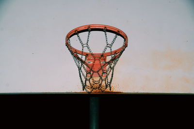 Low angle view of rusty basketball hoop at night