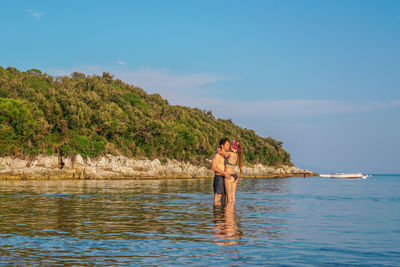 Rear view of woman standing in lake