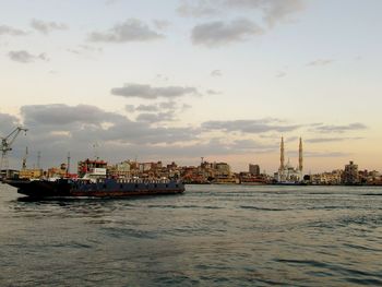 Nautical vessel on sea against sky during sunset