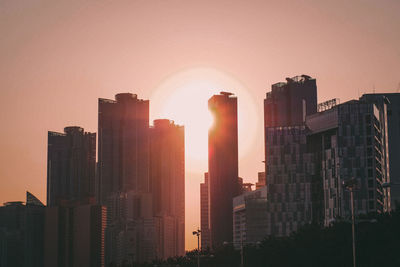 Modern buildings against sky during sunset