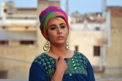 Beautiful young woman standing against building