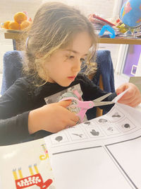 Close-up of girl studying on table