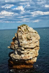 Rock formation in sea against sky