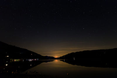 Scenic view of lake against sky at night